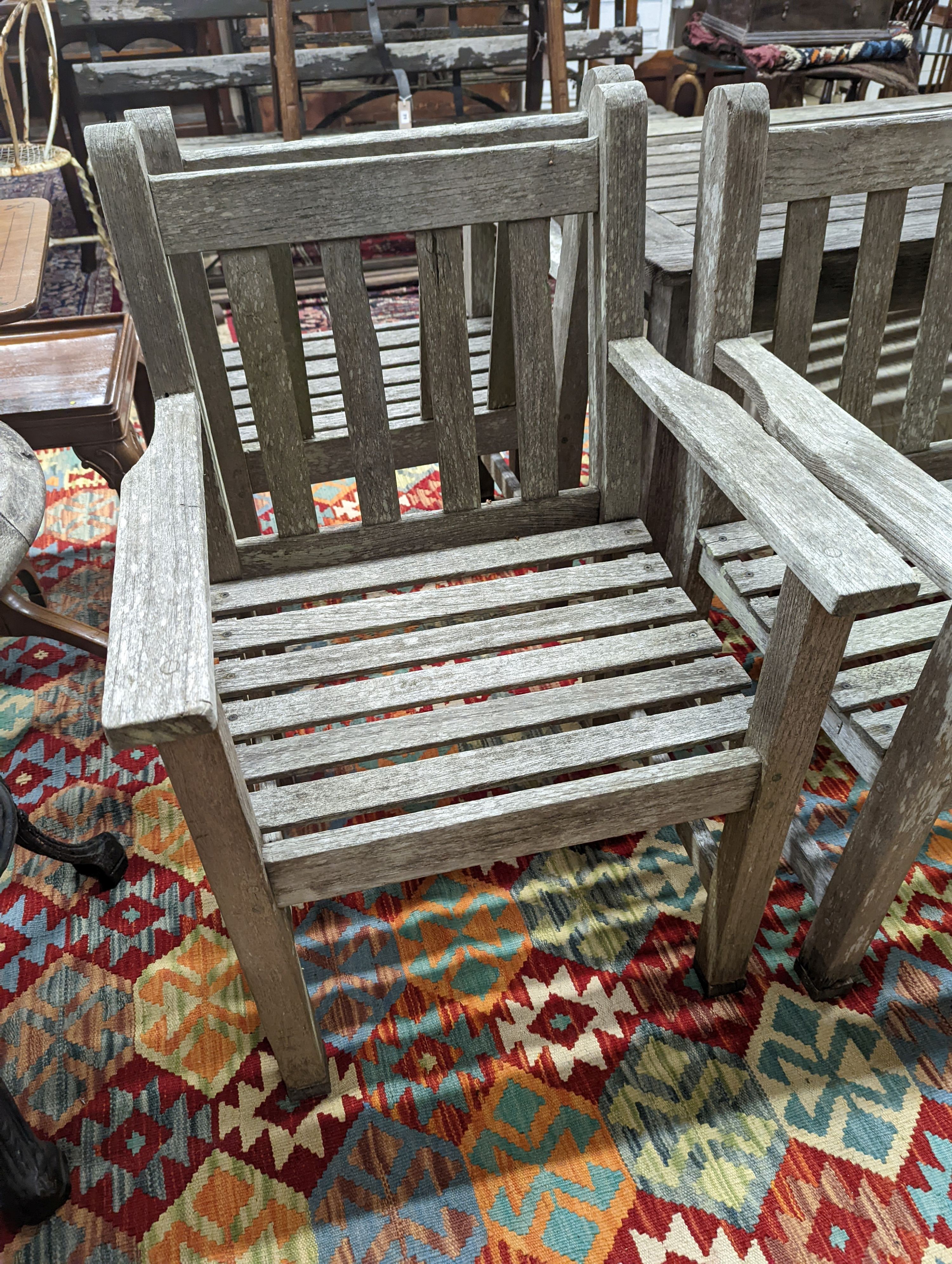 A Barlow type weathered teak garden suite, comprising rectangular table, length 149cm, depth 71cm, height 70cm, a bench and two armchairs